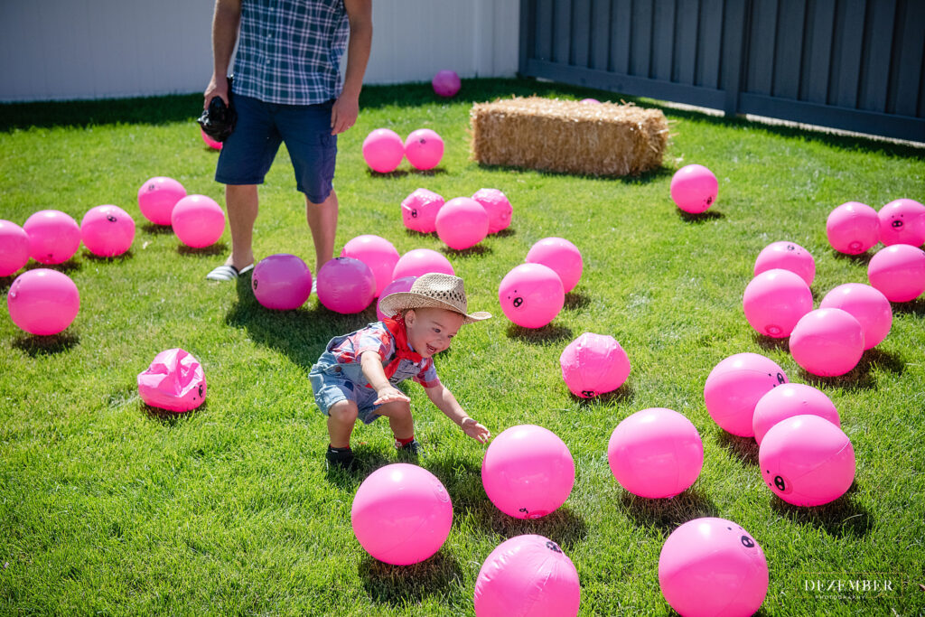 Boy plays with pink piggy inflatable ball