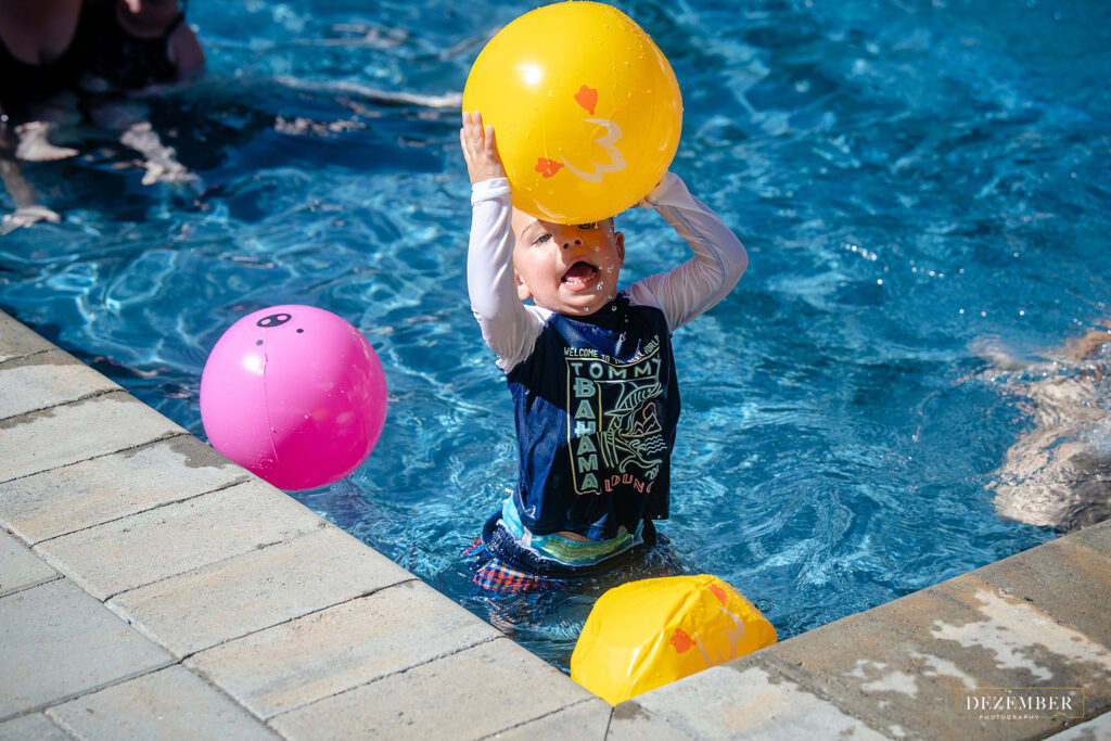 Boy throw yellow ball in the pool