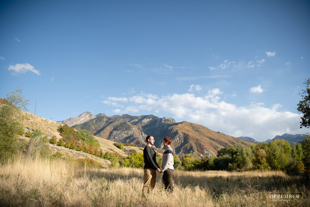 Couple faces each other holding hands near Big Cottonwood Canyon