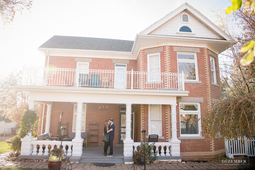 Couple kisses on porch of their Victorian Salt Lake City home