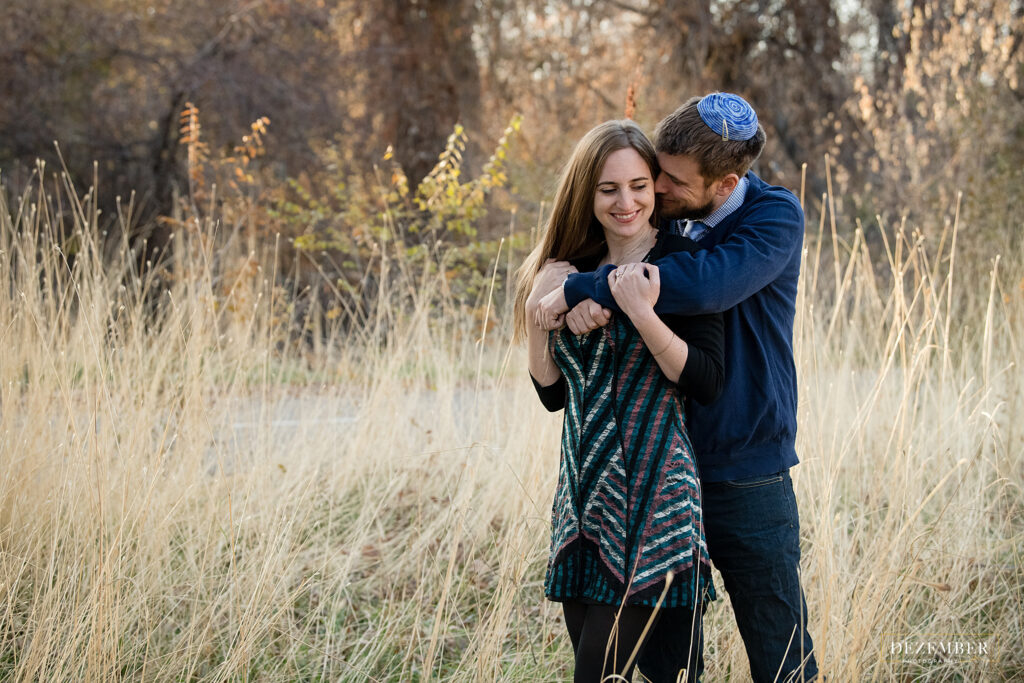 Man kisses fiance in field