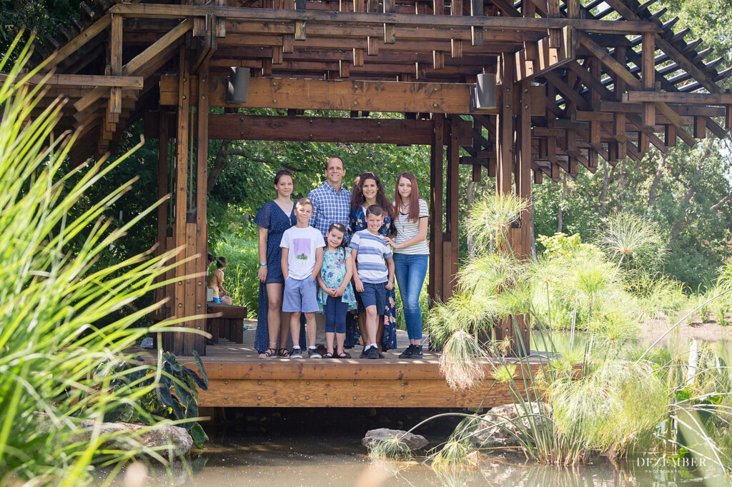 The family stands on a bridge at Red Butte Garden