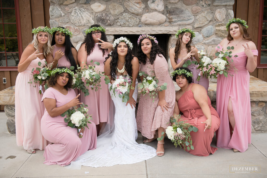 The bride and her bridemaids hold up peace hands for a picture