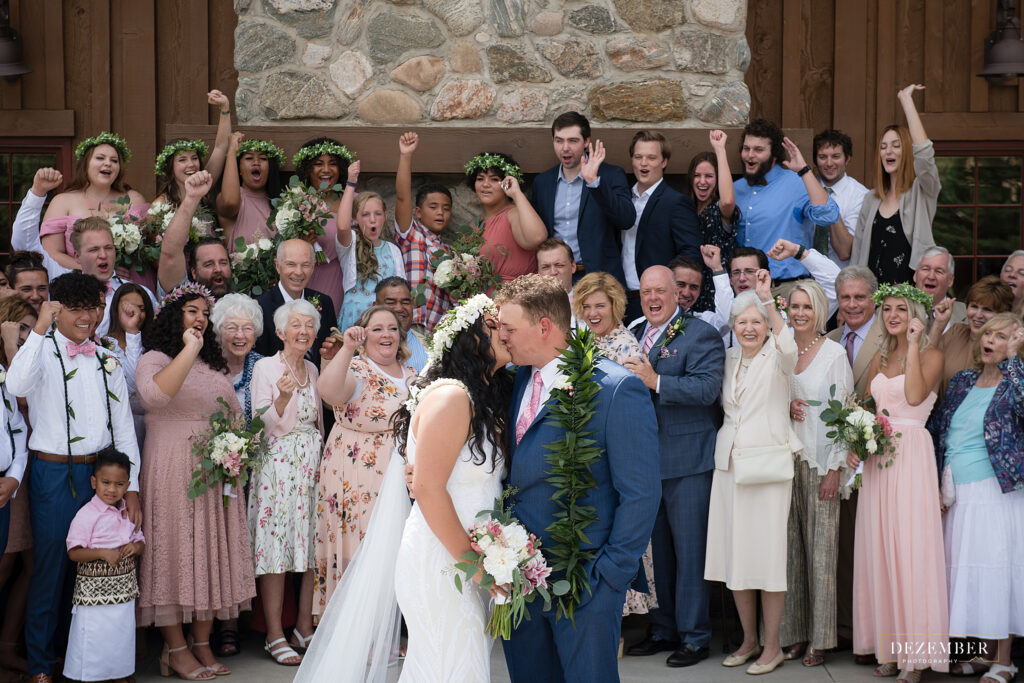 All the family cheers as bride and groom kiss