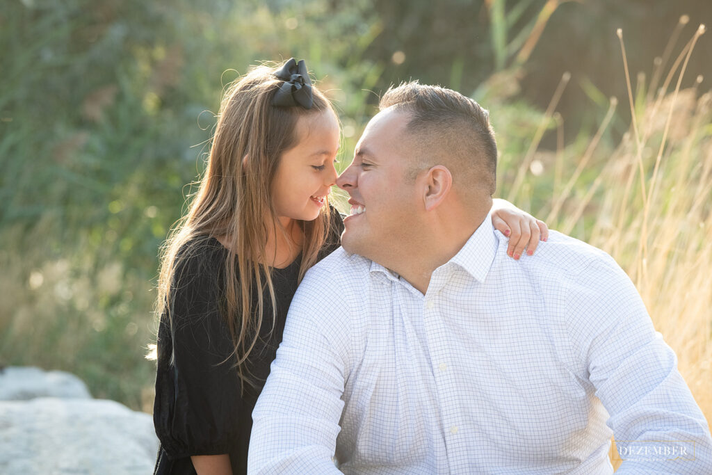 Dad and daughter give eskimo kisses with their noses