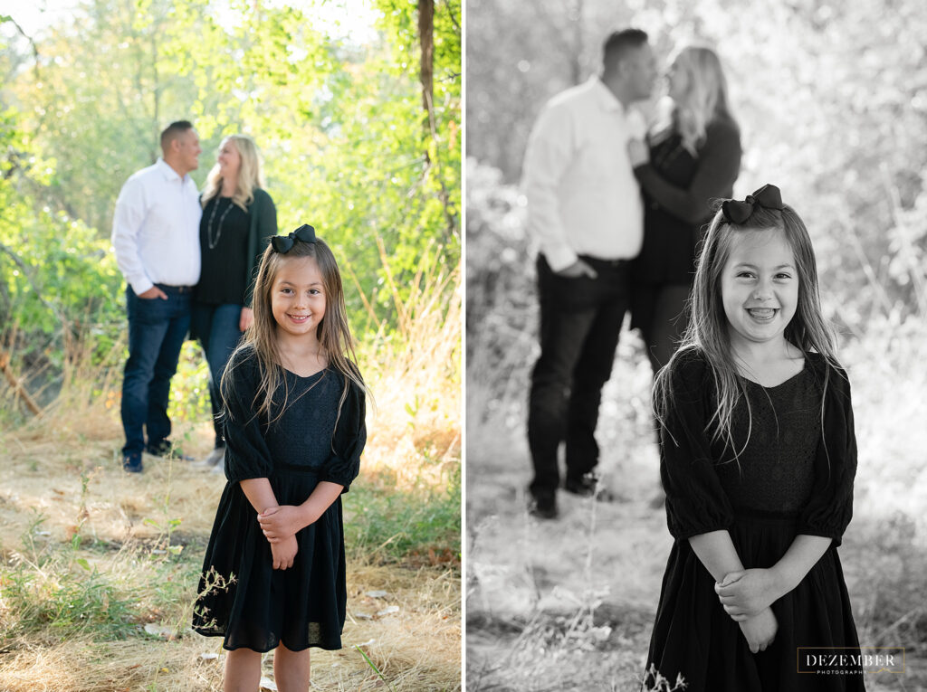 Girl laughs as her parents kiss in the background