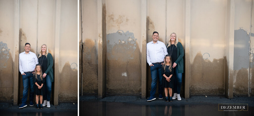 Family poses in front of cement wall