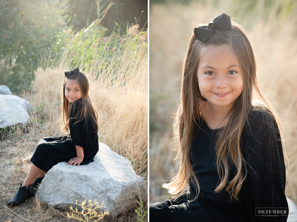 Little girl sits on rock in golden field