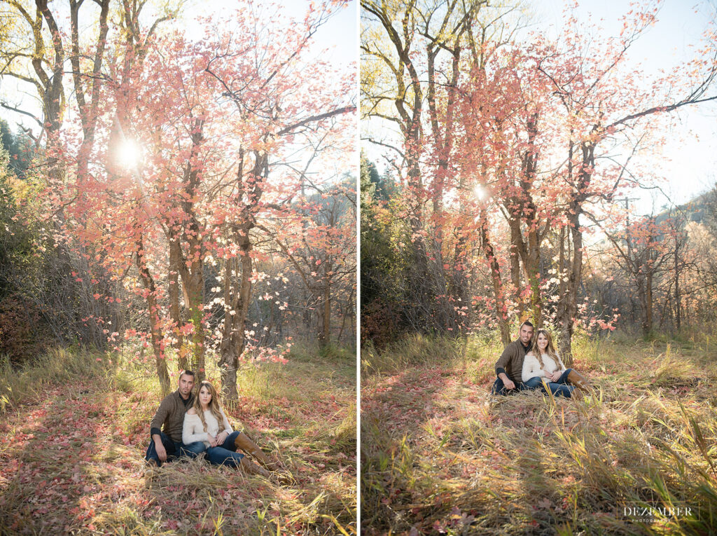 Couple sits beneath tree with red fall colors