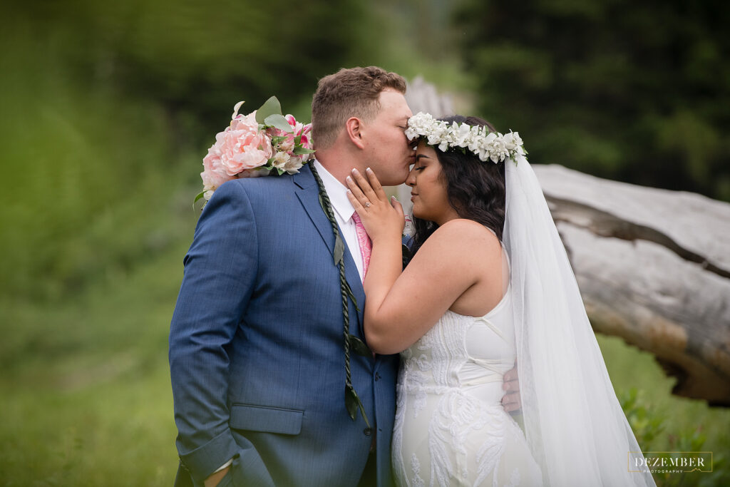 Groom kisses Polynesian bride on the forehead