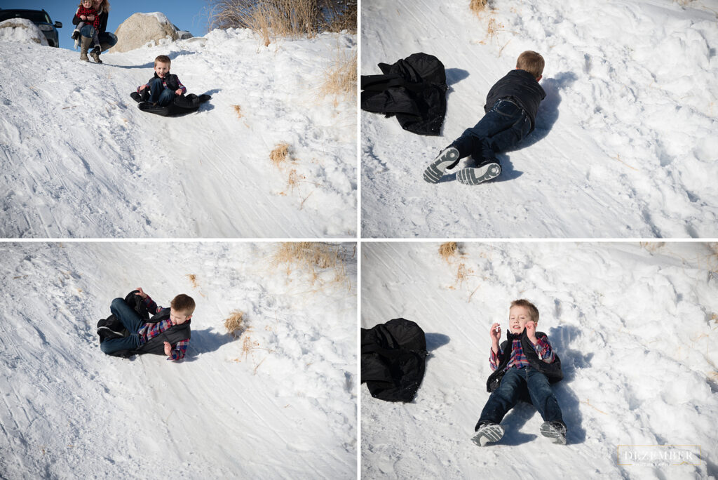 Snowy family portraits boy sledding down hill