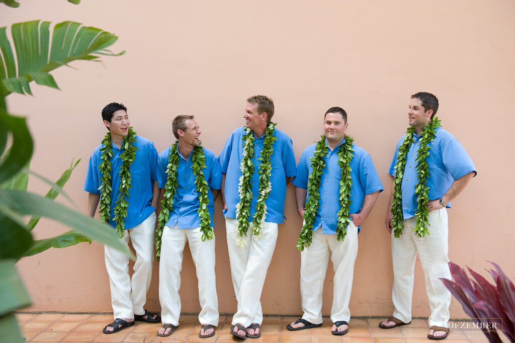 Groomsmen standing in front of a peach wall