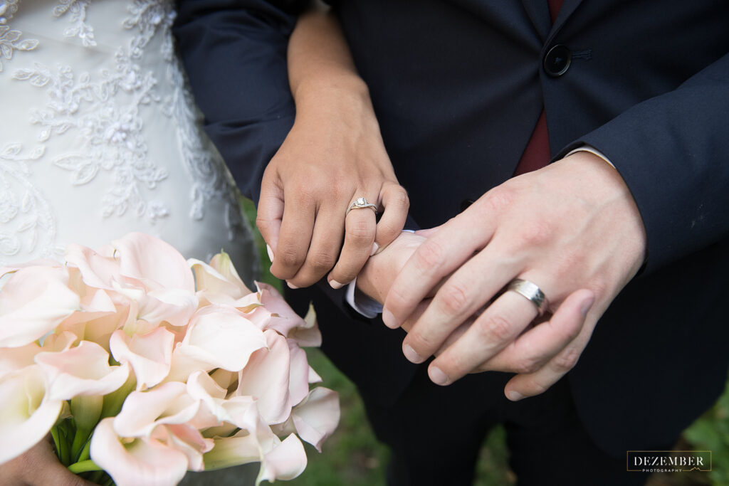 Detail of newlyweds holding hands